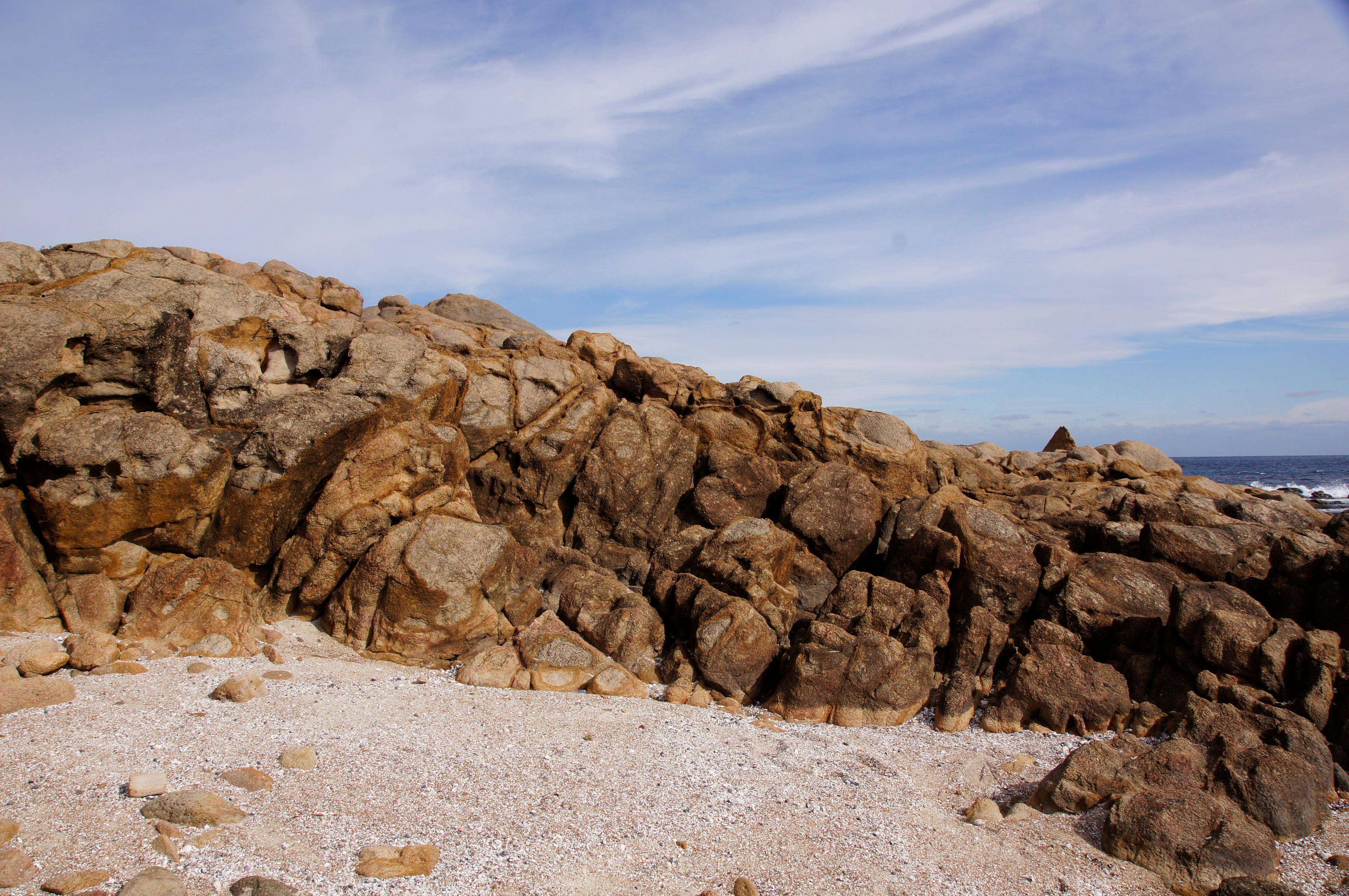 Rocks on a beach with a clear blue sky